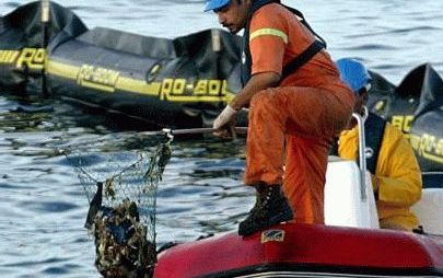 SHARM EL-SHEIKH - Een reddingswerker vist wrakstukken uit het water nadat een Boeing 737-300 van de Egyptische chartermaatschappij in de Rode Zee is gestort. Hierbij kwamen alle 148 inzittenden om het leven. Foto AFP