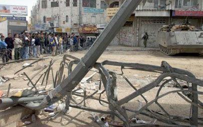 RAMALLAH - Palestijnse jongeren verzamelen zich achter prikkeldraadversperring tijdens een korte opheffing van de noodtoestand in de Westoeverstad. - Foto EPA