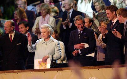 LONDEN - De opvolging van de Britse vorstin is het onderwerp van veel speculaties. Een van de mogelijke troonopvolgers is kroonprins Charles (r.), die maandag zijn moeder tijdens een popconcert op Buckingham Palace toesprak. - Foto EPA