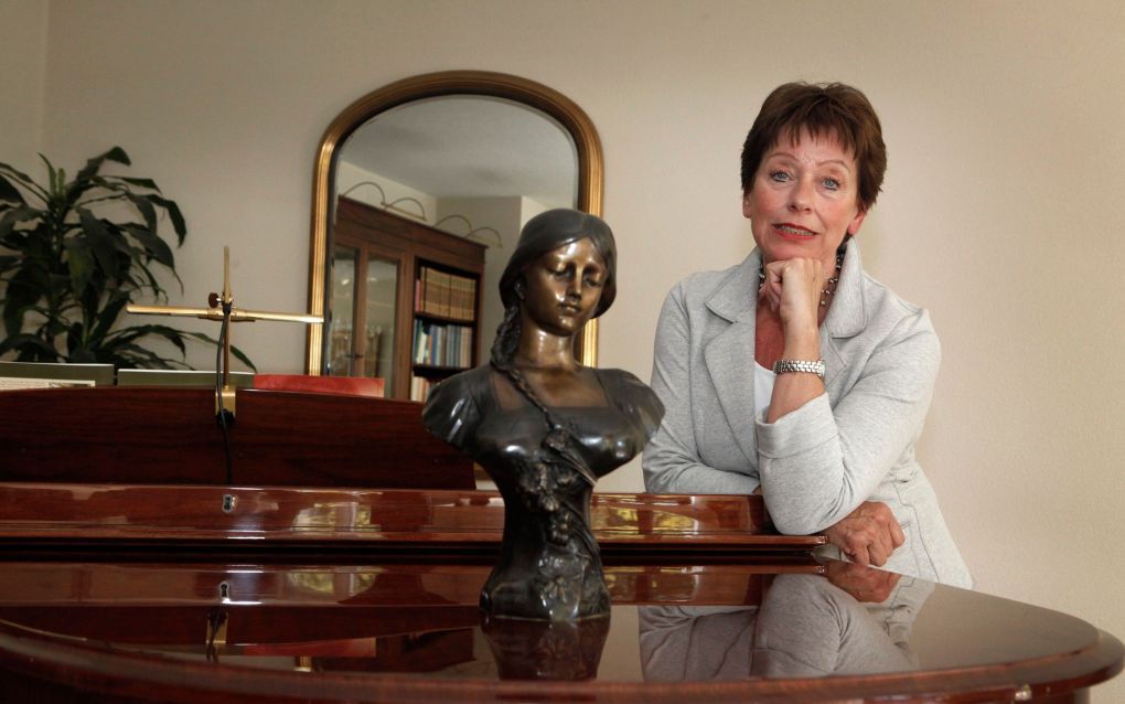 Tineke de Jong bij de vleugel van haar overleden man Addie. „Achter dit instrument bereidde hij zijn repetities en concerten voor en componeerde hij. Zelfs ’s nachts.” Foto Roel Dijkstra