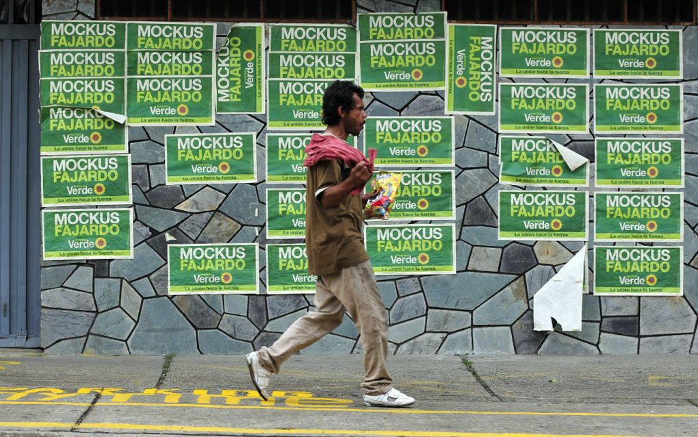 CALI - Een Colombiaan loopt in Cali langs een rij posters met daarop presidentskandidaat Antanas Mockus. Foto EPA