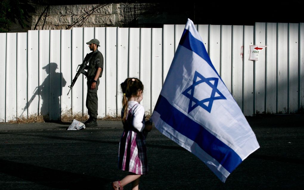 JERUZALEM - Een meisje loopt door Jeruzalem met de Israëlische vlag tijdens een mars voor de vrijlating van de ontvoerde Israëlische soldaat Gilad Shalit. Foto EPA