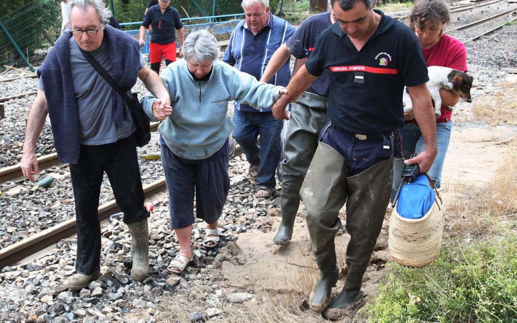 Reddingswerkers helpen evacués in het Zuid-Franse Arc sur Argens naar een beter heenkomen. Foto EPA