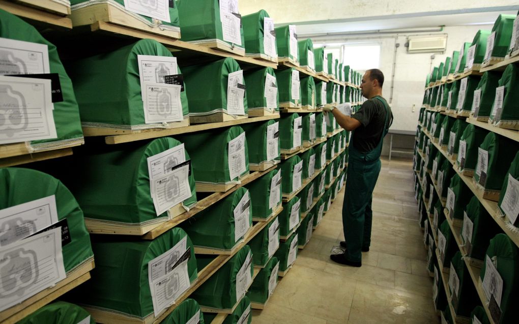 Een medewerker controleert in een mortuarium in de Bosnische stadje Visoko de naamplaatjes op de kisten met daarin de overblijfselen van de slachtoffers van de slachtpartij in Srebrenica in 1995. Foto EPA