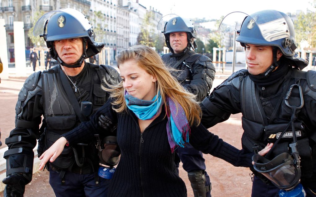 Een jongere in Lyon wordt afgevoerd door de oproerpolitie. Foto EPA