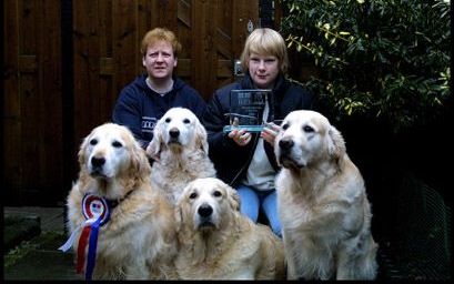 SLIEDRECHT - Ze zijn om door een ringetje te halen, de vier golden retrievers van Lijnie Bezemer (l.). Donja, met de strik, werd dit jaar kampioen bij een afslankwedstrijd. Een nichtje van Lijnie toont de bokaal die Donja kreeg. - Foto RD,HenkVisscher