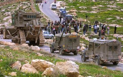 BETHLEHEM - Palestijnen verzamelen zich om te protesteren tegen de aanleg van een weg in het dorp Zatra, ten oosten van Bethlehem. IsraÃ«lische militairen kijken toe. De nieuwe route loopt van het oostelijke gedeelte van Hebron langs het oosten van Bethle