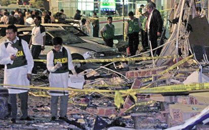 LIMA - De Peruaanse politie inspecteerde donderdagmorgen de ravage als gevolg van een bomaanslag bij de Amerikaanse ambassade in de hoofdstad Lima. - Foto EPA