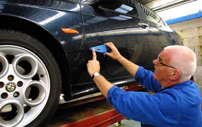 Schrijver meet de lakdikte om te kijken of de auto misschien is overgespoten.Â¶ Â¶ fotoverantwoording: Foto