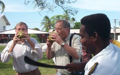 Burgemeester Deetman (m) drinkt samen met wethouder Pierre Heijnen van Den Haag uit een vers opengekapte kokosnoot in Nieuw-Nickerie, in het westen van Suriname. - Foto A. Snijders