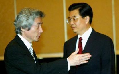 De Japanse premier Junichiro Koizumi verzoekt de Chinese president Hu Jintao plaats te nemen voordat er een begin wordt gemaakt met het overleg. Foto EPA