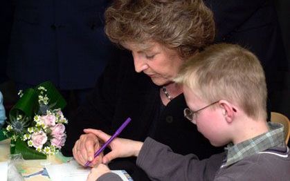 UDDEL - Bijgestuurd door Wim-Henk, kleurt prinses Margriet een doosje voor eigengemaakte kaarsen in. De prinses opende dinsdag de nieuwste instelling van Stichting Adullam Gehandicaptenzorg: Kroonheim in Uddel. - Foto Bram van de Biezen