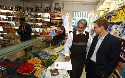 ROTTERDAM - Dr. Toby Howarth (r.) in gesprek met de eigenaar van een islamitische winkel bij hem in de buurt. Howarth, die vandaag is gepromoveerd op een onderwerp uit de islam, woont in de Rotterdamse wijk Delfshaven, vlak bij drie grote moskeeën en veel