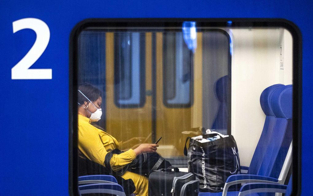 Een reiziger met een mondkapje op station Den Haag Centraal. De NS heeft opgeroepen om niet met de trein te reizen als dit niet strikt noodzakelijk is om zo de verspreiding van het coronavirus tegen te gaan. beeld ANP