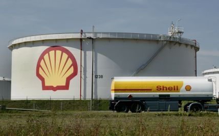 ROTTERDAM â€“ Opslagtanks en een tankwagen voor olie bij Shell Pernis. Marktleider Shell verhoogde zaterdag opnieuw de adviesprijzen voor brandstof. Sinds de invoering van de euro is autobrandstof nog nooit zo duur geweest. Foto: ANP