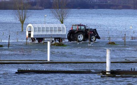 ROERMOND - De enige toegangsweg naar het gehucht De Weerd, nabij Roermond, was donderdag door het hoge Maaswater afgesloten voor het verkeer. De bewoners werden overgezet met behulp van een tractor met huifkar die tot een diepte van een meter door het wat