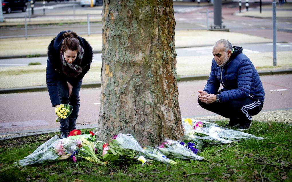 Een man bidt op de plek met bloemen op het 24 Oktoberplein, de dag na de aanslag waarbij drie mensen om het leven kwamen. beeld ANP