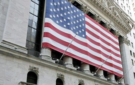 NEW YORK – Een inwoner van New York wandelt met z’n honden langs het beursgebouw op Wall Street. De aandelenkoersen in de VS –en ook wereldwijd– liepen de laatste tijd behoorlijke averij op. President Bush bepleitte vrijdag belastingplannen die de economi