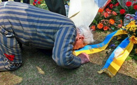 ORANIENBURG â€“ Een voormalige kampgevangene knielt bij een van de kransen die zondag werden gelegd tijdens een plechtigheid ter nagedachtenis aan de slachtoffers van nazi-concentratiekamp Sachsenhausen, dicht bij Oranienburg, Duitsland. Foto EPA