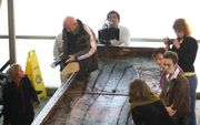 Gedeputeerde Baggerman onthulde gisteren de ”kano van de Wieringermeer”. In september vorig jaar werd deze 5000 jaar oude boomstamkano bij graafwerkzaamheden in het natuurontwikkelingsgebied Dijksgatsweide ontdekt. Foto ANP