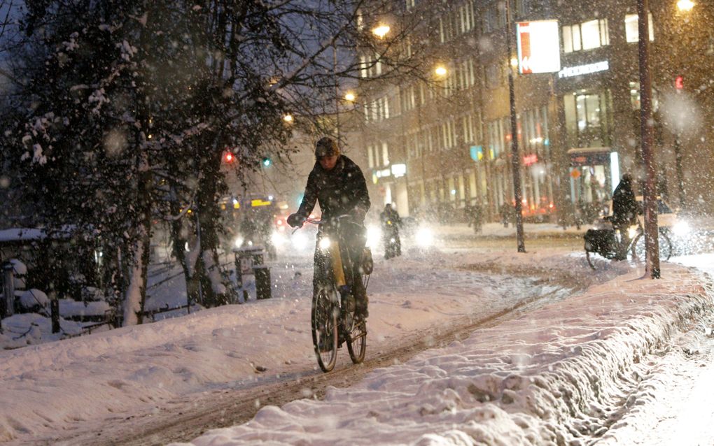 Een fietser baant zich in Groningen een weg door de sneeuw. Foto ANP