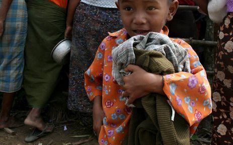 RANGOON - Kleding wordt uitgedeeld aan kinderen in een gebied waar nog geen hulpverlening geweest is. Mensen uit het dorp hebben kleding verzameld om dat uit te delen aan mensen die niets over hebben. Foto EPA