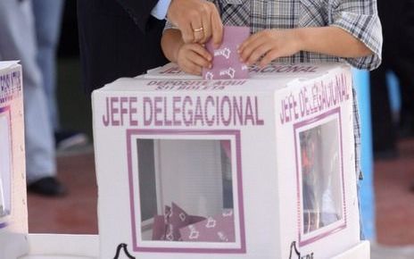 De Mexicaanse president Felipe Calderón bracht zondag tijdens de Mexicaanse presidentsverkiezingen zijn stem uit. Zijn zoon, Juan Pablo Calderon, hielp daarbij een handje. Foto EPA