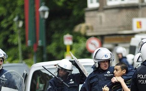 Een arrestant wordt afgevoerd in Anderlecht. Foto EPA