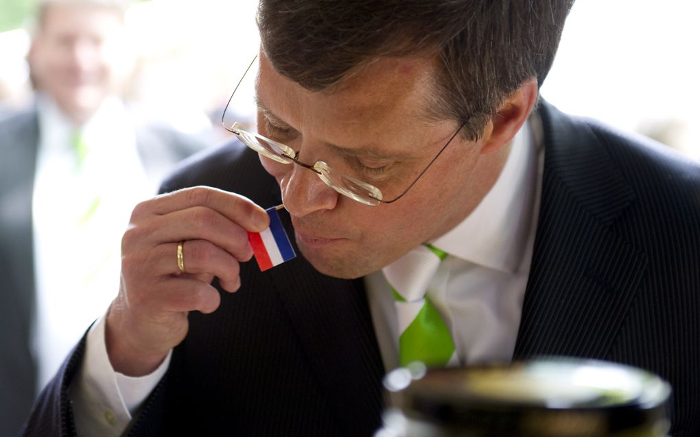 Demissionair premier Balkenende eet een haring dinsdag op de markt in Wassenaar. Foto ANP