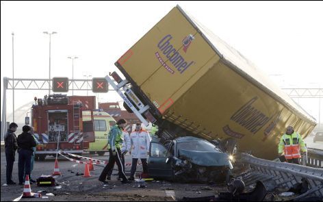 DEN HAAG - Een vrachtwagen balanceert maandagochtend op de A12 bij Nootdorp tussen twee weghelften. Door nog onbekende oorzaak reed de vrachtwagen over een personenauto heen en kantelde. Foto ANP