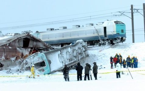 Reddingswerkers bij de ontspoorde trein. Foto EPA