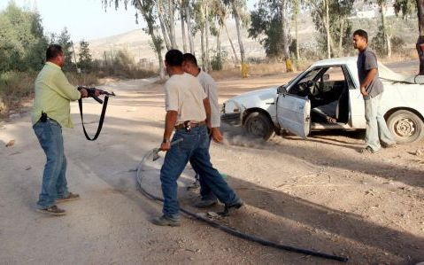 JENIN â€“ Een Palestijnse veiligheidsman schiet de banden van een auto lek om te voorkomen dat de bestuurder ervandoor gaat met spullen die hij uit de IsraÃ«lische militaire basis in Dotan heeft gestolen. Donderdag trok het IsraÃ«lische leger zich uit het