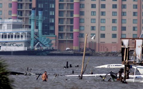 LAKE CHARLES - Een man uit Lake Charles (Verenigde Staten) baant zich een weg door het water om de schade van zijn boot te controleren die de orkaan Rita heeft aangebracht. Foto EPA