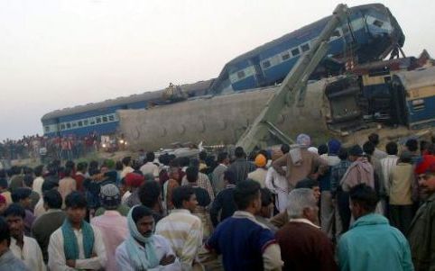 MANSAR- Dorpelingen kijken naar de reddingswerkzaamheden bij de wrakken van twee treinen die dinsdag op elkaar botsten bij Mansar, 150 kilometer ten oosten van Amritsar. Zeker 27 mensen kwamen om en 43 mensen raakten gewond. Foto EPA.