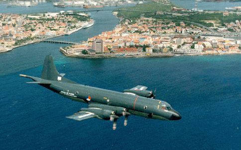 WILLEMSTAD â€“ Een Orion patrouillevliegtuig boven CuraÃ§ao. Defensie bezuinigt haar tien Orions weg en is voor de Antillen op zoek naar vervanging. Foto Koninklijke Marine