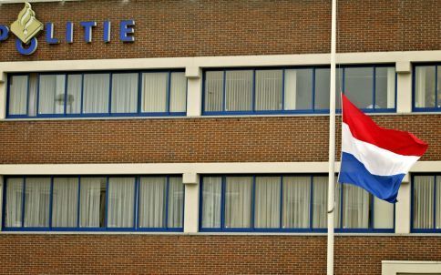 ENSCHEDE - De vlag hangt halfstok voor het politiebureau in Enschede op 6 oktober 2004, de dag van de crematie van Jan Wind. De rechtbank in Almelo heeft de 45-jarige Duitser Roedolf B. dinsdag veroordeeld tot een levenslange gevangenisstraf. De man schoo