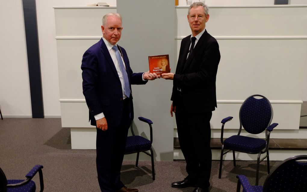 Ir. J.J. Zeeman (l.) overhandigt het boek "Gans begeerlijk" aan ds. P. den Ouden. beeld Gerrit van Dijk