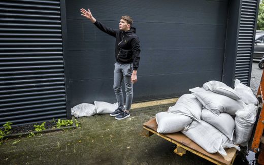 Een inwoner van Hoensbroek is in de weer met zandzakken. beeld ANP, Marcel van Hoorn
