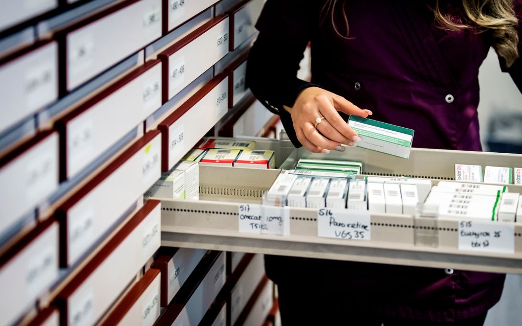 Een apothekersassistente zoekt medicijnen bij elkaar in een apotheek. beeld ANP, Koen van Weel