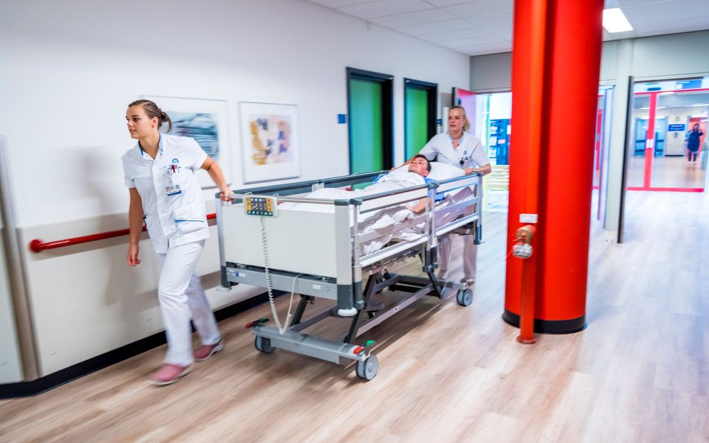 Verpleegkundigen met een patient in het ziekenhuis. Geen relatie tot artikel. beeld ANP, Lex van Lieshout