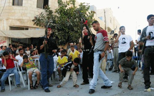 NABLUS - Palestijnse betogers schieten in de lucht tijdens een demonstratie van het Volksfront voor de Bevrijding van Palestina in het vluchtelingenkamp al-Ain. - Foto EPA