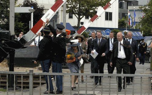 ALPHEN AAN DE RIJN - Tijdens het bezoek van koningin Beatrix gisteren aan Alphen aan den Rijn gingen plotseling de spoorbomen dicht. Enkele agenten probeerden het sluiten van de bomen te voorkomen. - Foto Roel Dijkstra