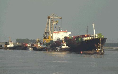 BATH - De berging van containerschip Pelican 1, dat zondag na een aanvaring op de Westerschelde met zware averij tegen de wal bij Bath is gezet, gaat nog ruim een week in beslag nemen. - Foto Willem Woznitza