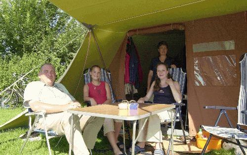 WESTERGEEST - Vader en moeder Broekhuizen uit Maastricht met in het midden hun dochters Imke (l.) en Maartje voor hun tent op boerencamping Hammerslag in het Friese Westergeest. Co: „Een kenner noemde onze tent eens de Rolls-Royce onder de tenten. - Foto 