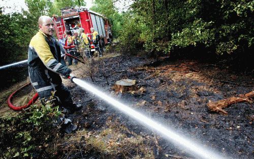 AMERONGEN - Brandweerlieden blussen een bosbrand in de omgeving van Amerongen. Daar ontstonden gisteren plotseling op diverse plaatsen branden. De politie heeft inmiddels een 29-jarige man uit Veenendaal aangehouden. Hij wordt ervan verdacht het vuur te h