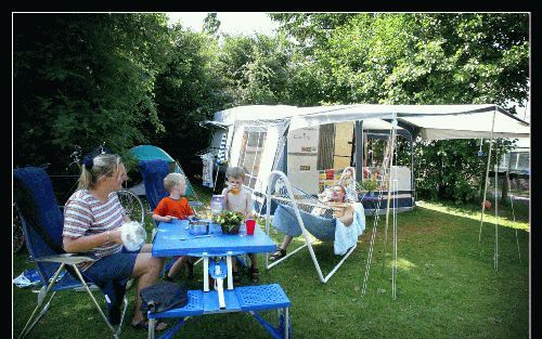 VOORTHUIZEN - Tino en Mieke Keesenberg met hun zonen Martijn en Reinier voor hun caravan op de evangelische camping ’t Beloofde Land in Voorthuizen. „De bindende factor is dat iedereen in God gelooft. Theologische kwesties zijn niet belangrijk op vakantie