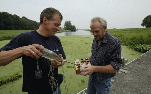 MOORDRECHT - Harry Berkouwer (l.) en Jan Roos van Hoogheemraadschap Schieland testen bij het Moordrechtse Abraham Kroes-gemaal het brakke water van de zuidelijke Zuidplaspolder. „Met al onze ingrepen proberen we het zoetste water te gebruiken en het zoute