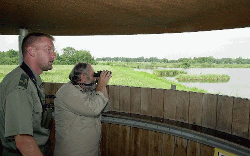 SINT JANSKLOOSTER - Boswachter J. Hooijmeijer (l.) en beleidsmedewerker H. Piek van Natuurmonumenten kijken uit over de Wieden. „Behalve bij de Oostvaardersplassen is dit de enige plek in Nederland waar lepelaars hun nest bouwen.” - Foto Sieb van der Laan