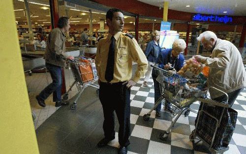 GOUDA - De beveiligingsbeambte van de Albert Heijn-supermarkt in het Goudse winkelcentrum Goverwelle kijkt naar buiten. Jongeren hangen vaak voor de ingang rond. „Ze willen rotzooi trappen: bijvoorbeeld een blikje opentrekken en leeg laten lopen.” - Foto 