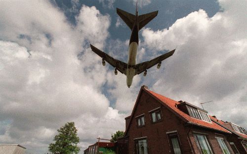 AMSTERDAM - Een vliegtuig scheert over een huis in de omgeving van Schiphol. De luchthaven is van plan de woningen te kopen van mensen in Aalsmeer en Zwanenburg die vanwege de geluidsoverlast weg willen. - Foto ANP